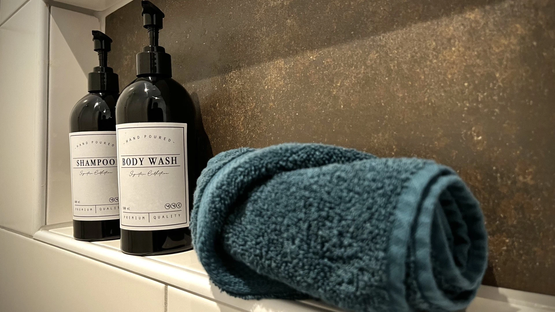 Shampoo, douchegel en een opgerolde handdoek