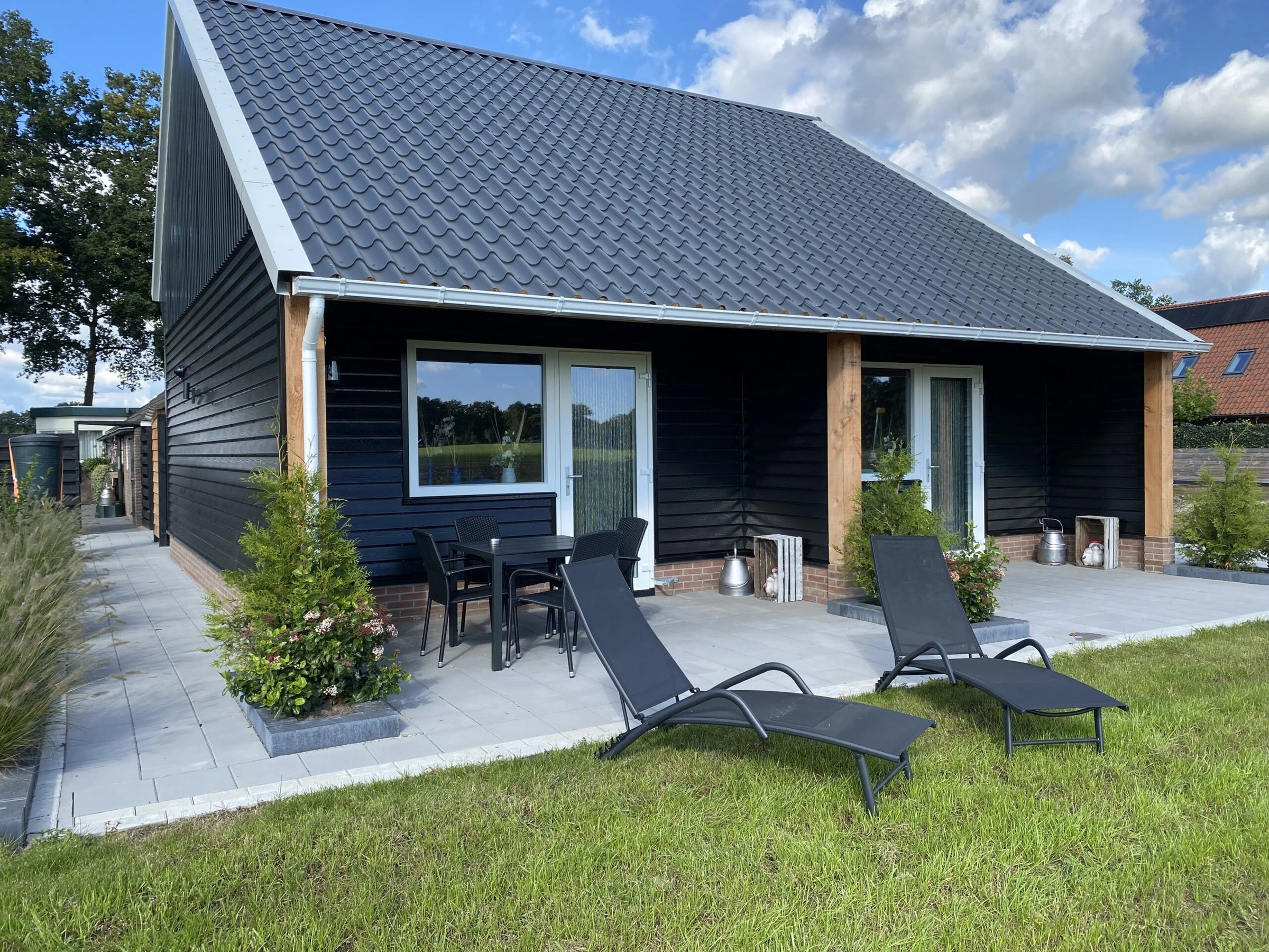 De kapschuur van opzij, met het grasveld en de ligstoelen
