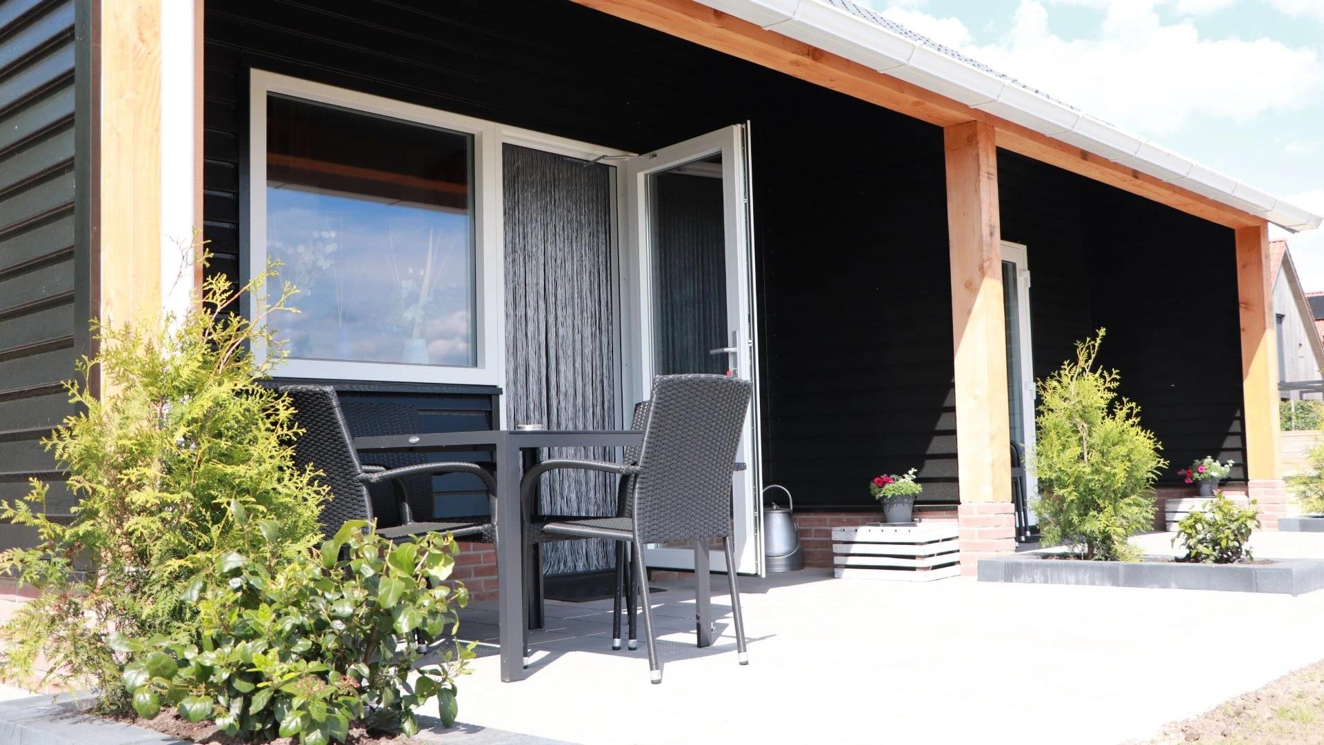 Het terras met zithoek voor een van de huisjes